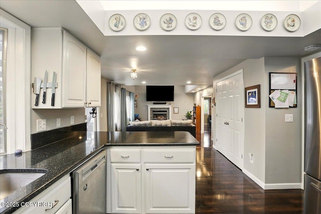 12830 Mission Cir, Anchorage, AK 99516 - kitchen featuring stainless steel appliances, a peninsula, dark wood-type flooring, a sink, and white cabinetry