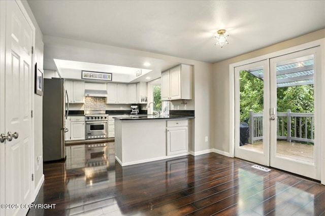 12830 Mission Cir, Anchorage, AK 99516 - kitchen with stainless steel appliances, extractor fan, dark countertops, a peninsula, and healthy amount of natural light