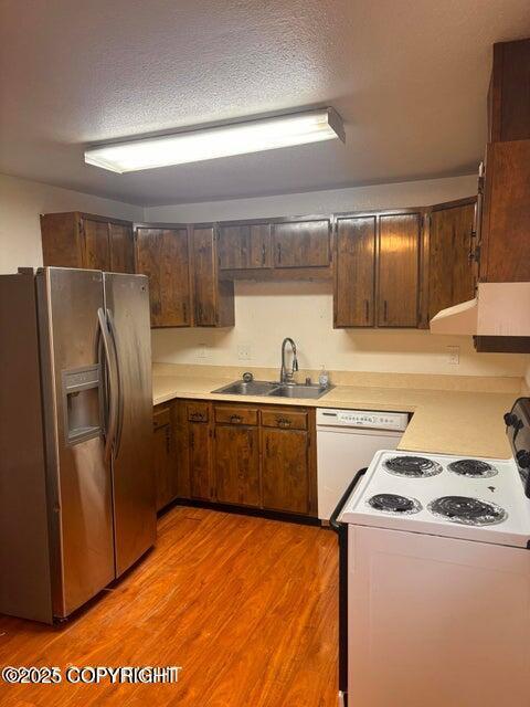 810 E 79th Ave, Anchorage, AK 99518 - kitchen featuring white appliances, under cabinet range hood, light wood finished floors, and light countertops