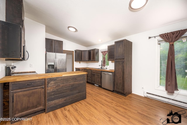 5275 E Birch Dr, Wasilla, AK 99654 - kitchen featuring stainless steel appliances, butcher block countertops, dark brown cabinets, vaulted ceiling, and a baseboard radiator