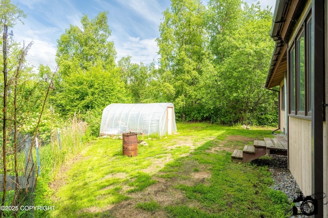 5275 E Birch Dr, Wasilla, AK 99654 - view of grassy yard featuring a greenhouse and an outbuilding