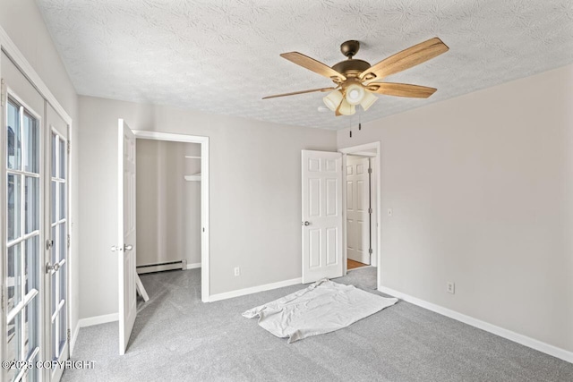 1100 Fred Cir, Anchorage, AK 99515 - unfurnished bedroom with a baseboard radiator, carpet floors, baseboards, a walk in closet, and a textured ceiling