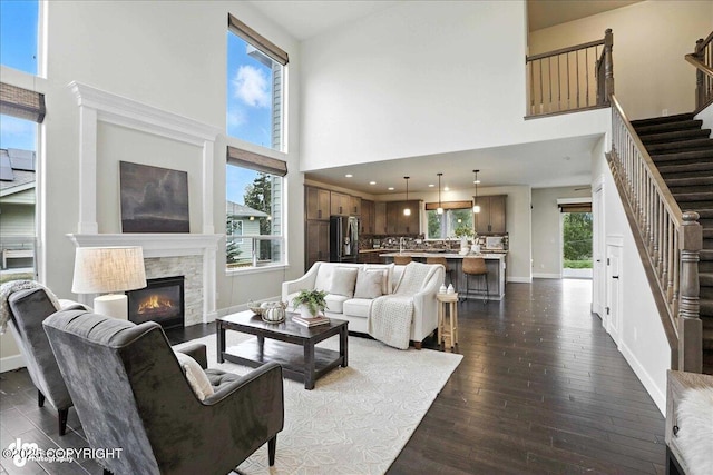 8683 Estates Cir, Anchorage, AK 99507 - living room featuring stairway, a high ceiling, dark wood finished floors, and a fireplace