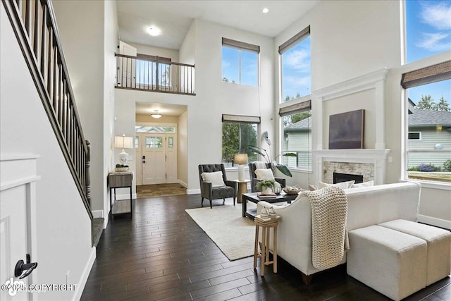 8683 Estates Cir, Anchorage, AK 99507 - living area featuring healthy amount of natural light, dark wood finished floors, a fireplace, a high ceiling, and stairs