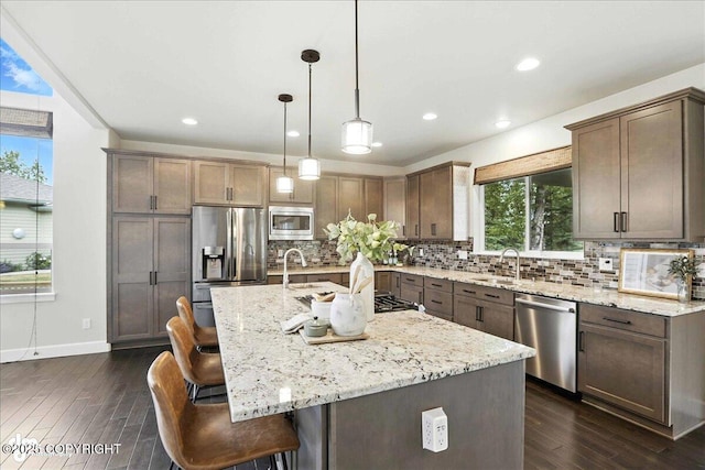 8683 Estates Cir, Anchorage, AK 99507 - kitchen featuring appliances with stainless steel finishes, dark wood-type flooring, light stone counters, tasteful backsplash, and recessed lighting