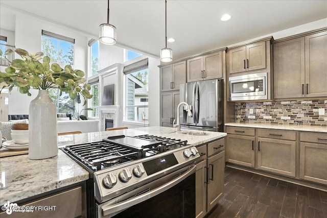 8683 Estates Cir, Anchorage, AK 99507 - kitchen featuring stainless steel appliances, dark wood-type flooring, light stone countertops, tasteful backsplash, and decorative light fixtures