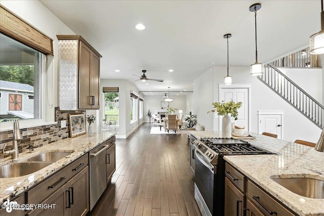 8683 Estates Cir, Anchorage, AK 99507 - kitchen with stainless steel appliances, ceiling fan, tasteful backsplash, dark wood-style flooring, and decorative light fixtures