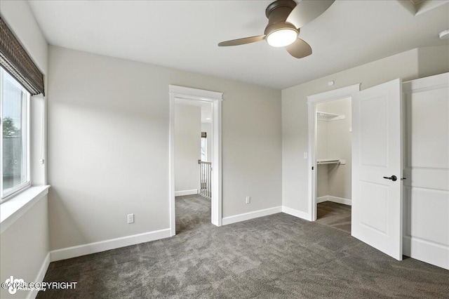 8683 Estates Cir, Anchorage, AK 99507 - unfurnished bedroom featuring carpet flooring, a walk in closet, and a ceiling fan
