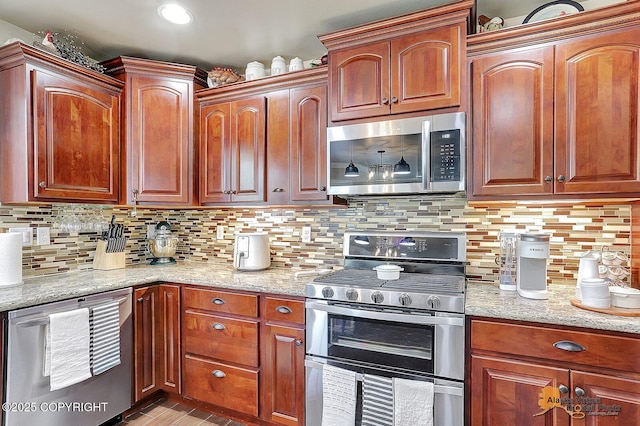 2548 S Gallop Cir, Wasilla, AK 99654 - kitchen featuring stainless steel appliances, light stone counters, tasteful backsplash, and light wood-type flooring