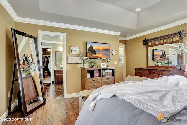 2548 S Gallop Cir, Wasilla, AK 99654 - bedroom with wood finished floors, crown molding, a tray ceiling, a spacious closet, and ensuite bathroom