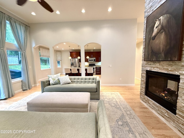 14740 Maxwell Pl, Anchorage, AK 99516 - living area featuring arched walkways, ceiling fan, light wood-style flooring, recessed lighting, and a fireplace