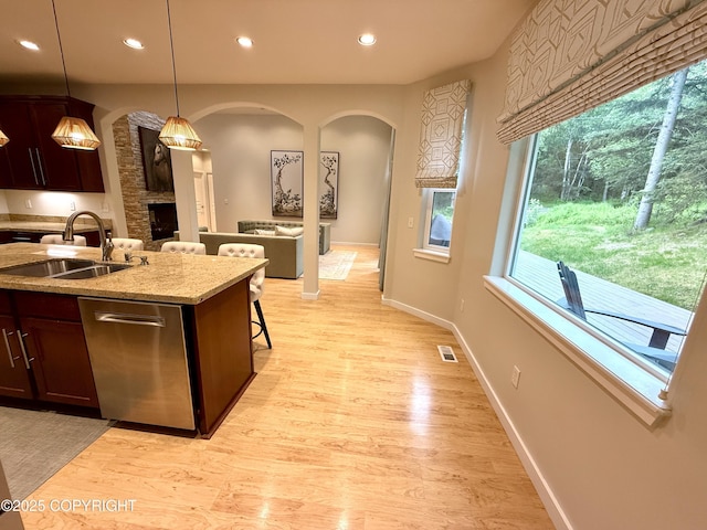 14740 Maxwell Pl, Anchorage, AK 99516 - kitchen featuring a sink, arched walkways, stainless steel dishwasher, recessed lighting, and light wood finished floors