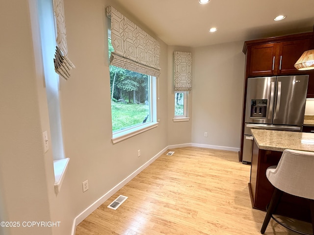 14740 Maxwell Pl, Anchorage, AK 99516 - kitchen featuring stainless steel fridge with ice dispenser, baseboards, recessed lighting, light wood-style flooring, and light stone countertops