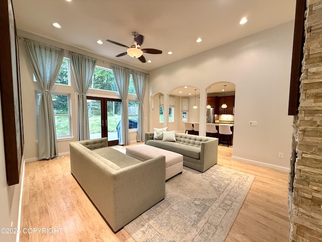 14740 Maxwell Pl, Anchorage, AK 99516 - living room featuring arched walkways, a ceiling fan, recessed lighting, light wood-style floors, and baseboards