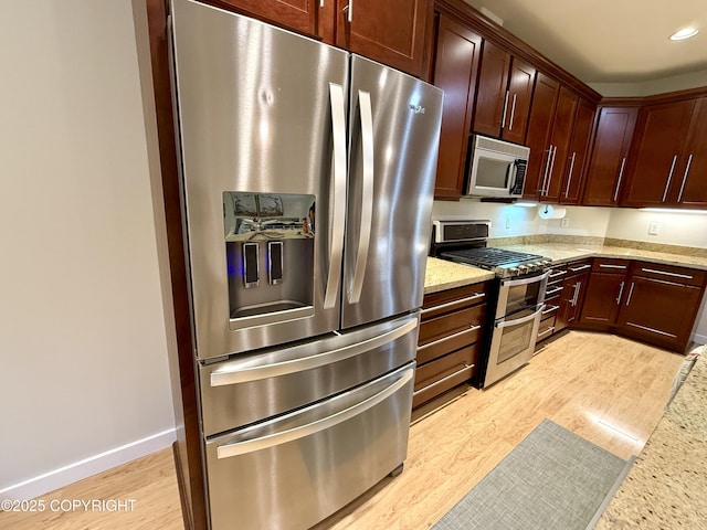 14740 Maxwell Pl, Anchorage, AK 99516 - kitchen featuring appliances with stainless steel finishes, light wood-type flooring, light stone counters, baseboards, and recessed lighting