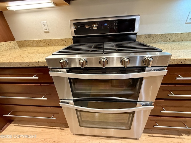 14740 Maxwell Pl, Anchorage, AK 99516 - kitchen with range with two ovens, light stone countertops, and light wood-style floors