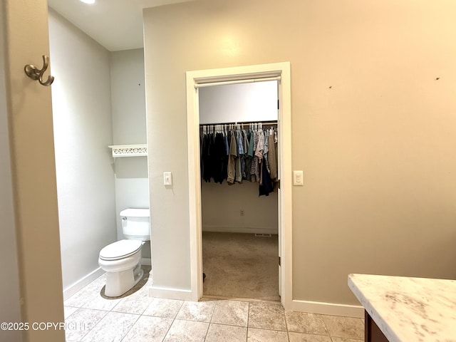 14740 Maxwell Pl, Anchorage, AK 99516 - bathroom featuring toilet, baseboards, tile patterned flooring, a spacious closet, and vanity