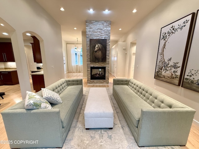 14740 Maxwell Pl, Anchorage, AK 99516 - living area with recessed lighting, arched walkways, light wood-type flooring, a stone fireplace, and baseboards
