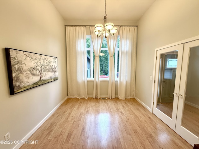 14740 Maxwell Pl, Anchorage, AK 99516 - unfurnished dining area featuring wood finished floors, a chandelier, french doors, and baseboards