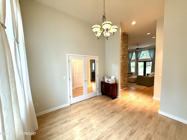 14740 Maxwell Pl, Anchorage, AK 99516 - spare room featuring a chandelier, light wood-style flooring, baseboards, recessed lighting, and a towering ceiling
