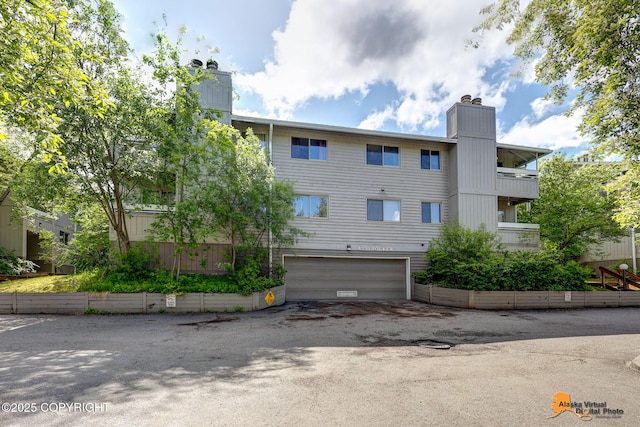 4221 Folker St # F203, Anchorage, AK 99508 - view of building exterior featuring an attached garage