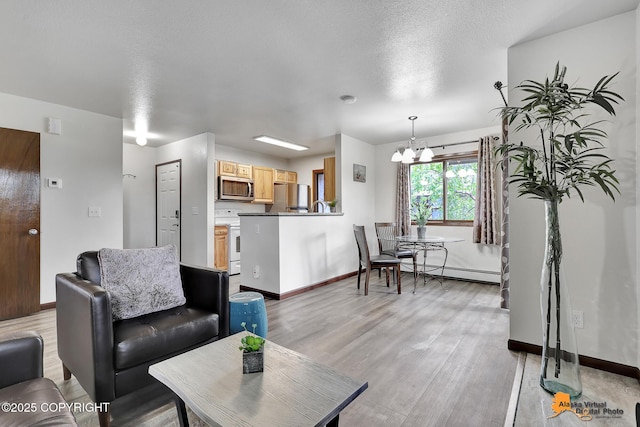 4221 Folker St # F203, Anchorage, AK 99508 - living room with a chandelier, a baseboard heating unit, and light wood-style flooring