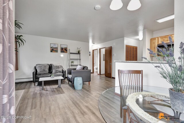 4221 Folker St # F203, Anchorage, AK 99508 - living area with a baseboard heating unit and light wood finished floors