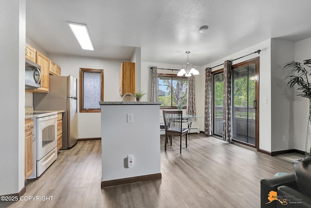 4221 Folker St # F203, Anchorage, AK 99508 - kitchen with stainless steel appliances, light wood-style flooring, a chandelier, light brown cabinets, and hanging light fixtures