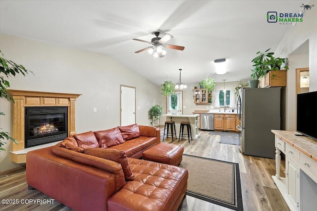 8520 E Gold Bullion Blvd, Palmer, AK 99645 - living area with a glass covered fireplace, light wood finished floors, a ceiling fan, lofted ceiling, and a chandelier