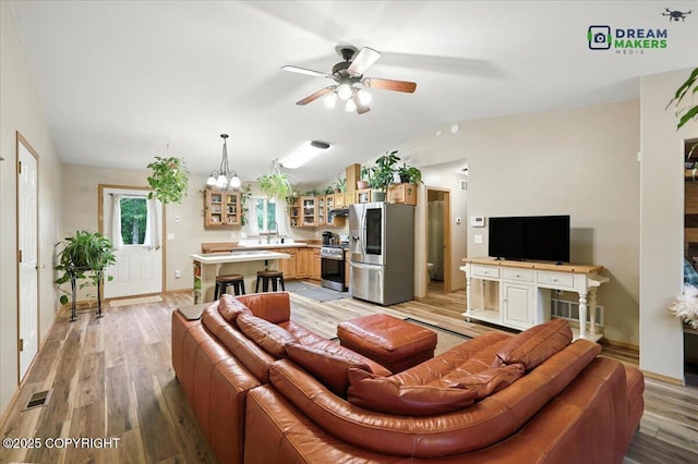 8520 E Gold Bullion Blvd, Palmer, AK 99645 - living room with light wood-style flooring, a ceiling fan, a chandelier, and vaulted ceiling