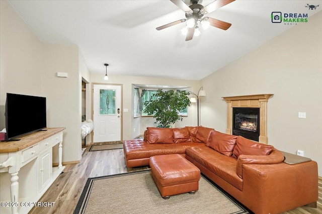 8520 E Gold Bullion Blvd, Palmer, AK 99645 - living room featuring a glass covered fireplace, light wood-type flooring, ceiling fan, and vaulted ceiling