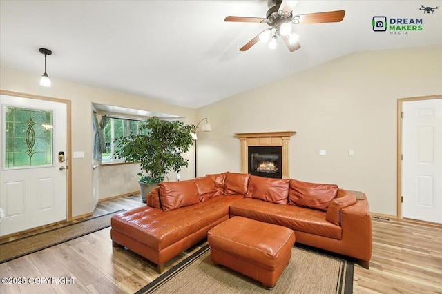 8520 E Gold Bullion Blvd, Palmer, AK 99645 - living room featuring light wood finished floors, vaulted ceiling, ceiling fan, and a glass covered fireplace