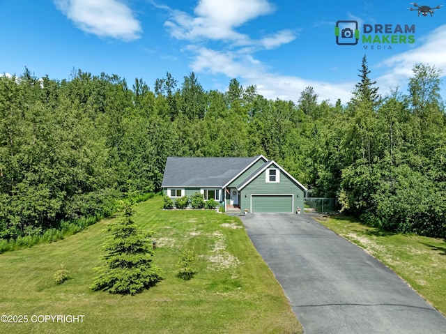 3111 N Intuition Dr, Wasilla, AK 99654 - view of front of property featuring a front yard, asphalt driveway, a view of trees, and an attached garage