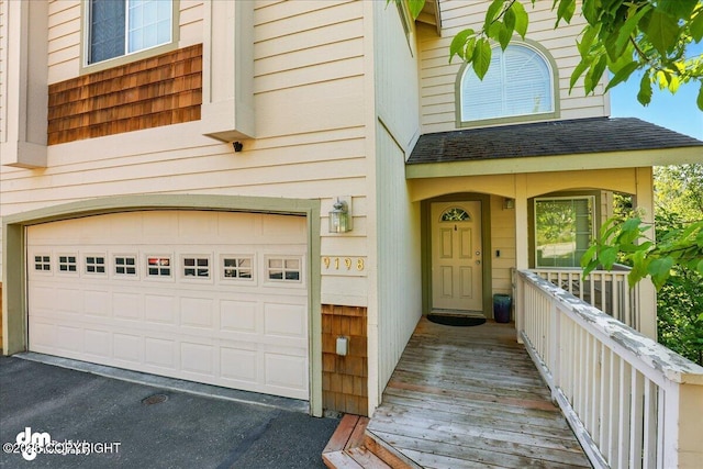 9198 Eagle River Ln, Eagle River, AK 99577 - property entrance featuring a garage, asphalt driveway, and a shingled roof