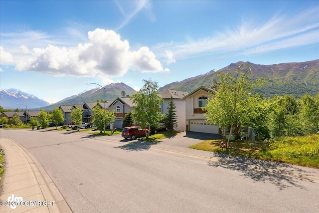 9198 Eagle River Ln, Eagle River, AK 99577 - view of asphalt road featuring sidewalks, a mountain view, street lights, curbs, and a residential view