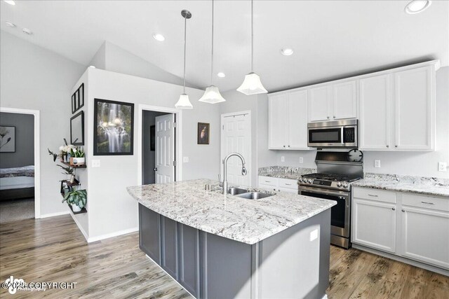 9198 Eagle River Ln, Eagle River, AK 99577 - kitchen featuring stainless steel appliances, a kitchen island with sink, white cabinets, lofted ceiling, and recessed lighting