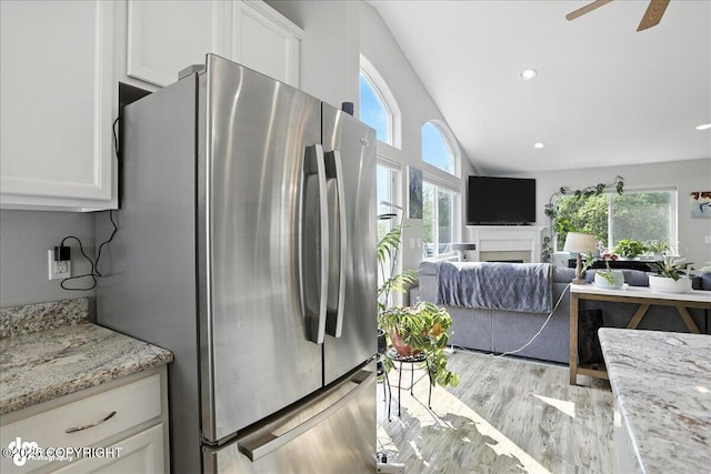 9198 Eagle River Ln, Eagle River, AK 99577 - kitchen with freestanding refrigerator, plenty of natural light, wood finished floors, white cabinets, and vaulted ceiling