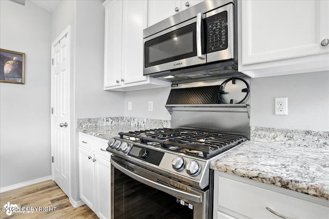 9198 Eagle River Ln, Eagle River, AK 99577 - kitchen with appliances with stainless steel finishes, light wood-style floors, white cabinetry, and light stone counters