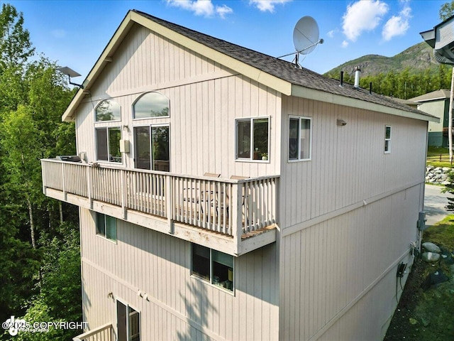 9198 Eagle River Ln, Eagle River, AK 99577 - view of property exterior with a balcony, a mountain view, and a shingled roof