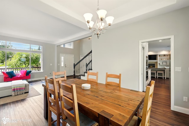 17001 Yellowstone Dr, Eagle River, AK 99577 - dining space featuring wood finished floors, stairs, a chandelier, and crown molding