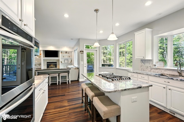 17001 Yellowstone Dr, Eagle River, AK 99577 - kitchen featuring stainless steel gas stovetop, open floor plan, recessed lighting, white cabinets, and a kitchen island