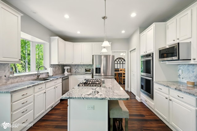 17001 Yellowstone Dr, Eagle River, AK 99577 - kitchen with stainless steel appliances, tasteful backsplash, white cabinets, a kitchen island, and recessed lighting
