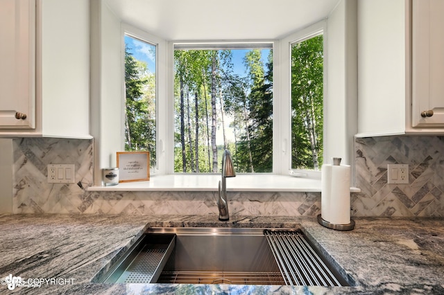 17001 Yellowstone Dr, Eagle River, AK 99577 - detailed view of decorative backsplash, light stone countertops, and white cabinetry
