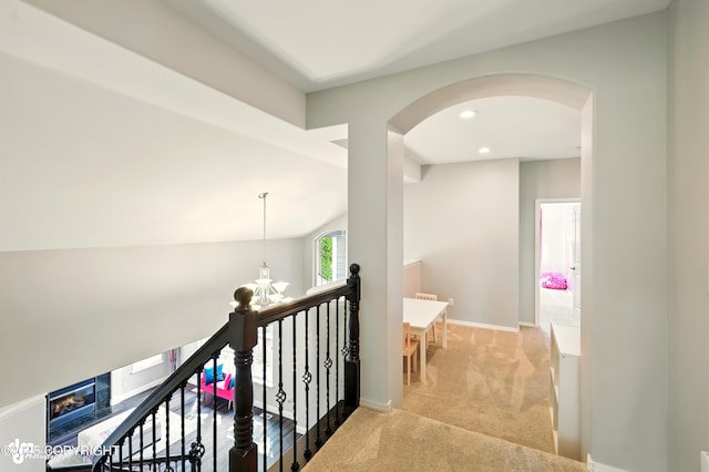 17001 Yellowstone Dr, Eagle River, AK 99577 - hallway featuring carpet floors, a chandelier, arched walkways, recessed lighting, and an upstairs landing