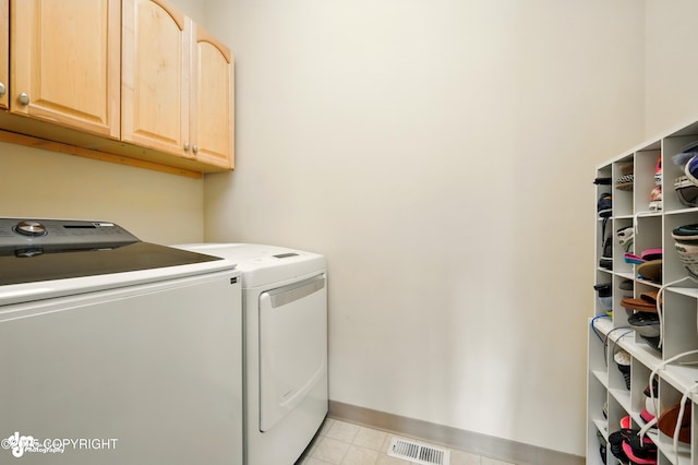 17001 Yellowstone Dr, Eagle River, AK 99577 - laundry room with washing machine and clothes dryer, cabinet space, and light tile patterned flooring