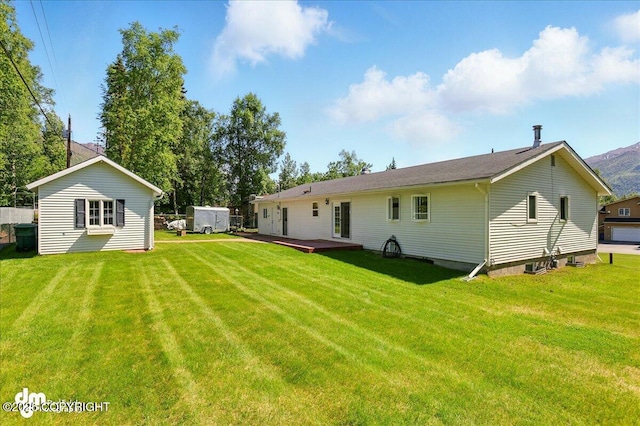 19807 First St, Eagle River, AK 99577 - rear view of house with a wooden deck and a yard