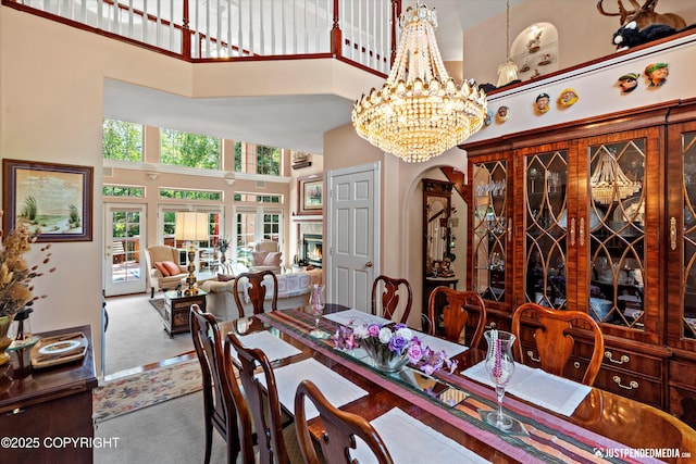 2215 S Austin Cir, Palmer, AK 99645 - carpeted dining area with a towering ceiling, arched walkways, and a chandelier