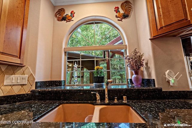 2215 S Austin Cir, Palmer, AK 99645 - kitchen featuring decorative backsplash, dark stone counters, brown cabinetry, ornamental molding, and a textured wall