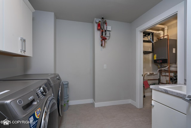 528 Coastal Pl # 1, Anchorage, AK 99501 - washroom with cabinet space, washer and clothes dryer, water heater, and baseboards