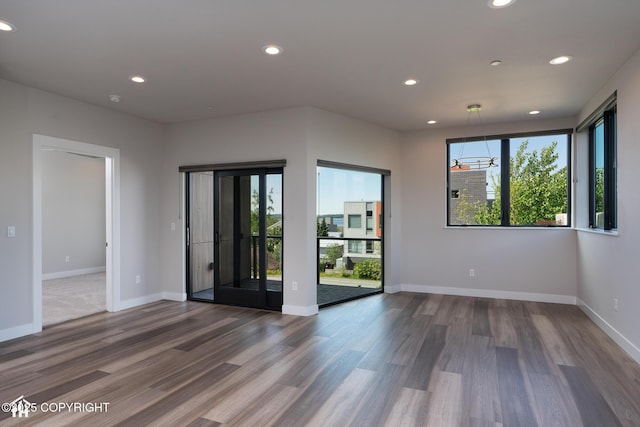 528 Coastal Pl # 1, Anchorage, AK 99501 - empty room with plenty of natural light, recessed lighting, wood finished floors, and baseboards